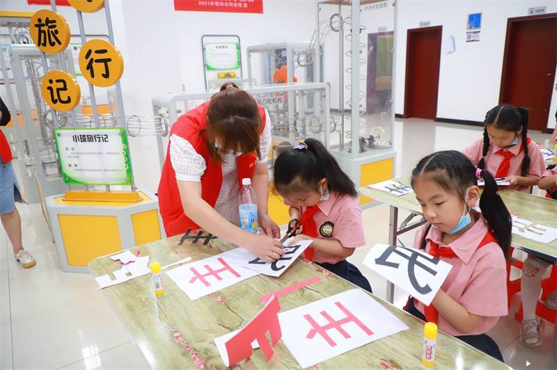 2021年7月10日，鄂州市科協(xié)組織落駕坪小學(xué)學(xué)生在鄂州市科技館開展社會(huì)主義核心價(jià)值觀系列活動(dòng)，圖為開展的紅色剪影圓夢中華剪紙活動(dòng)，志愿者指導(dǎo)同學(xué)們.jpg