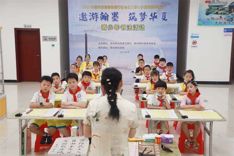 2021年7月10日，鄂州市科協(xié)組織蓮花小學(xué)學(xué)生在鄂州市科技館開展社會主義核心價值觀系列活動，圖為開展的遨游翰墨筑夢華夏書法活動，老師講解握筆姿勢2.jpg